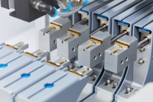 Close-up of 4 CYC802 modules, mounted as a quad-cyc, mid-measurement. The crimped hair fibre samples can be seen in varying stages of the torsion measurements, from slack to fully taught